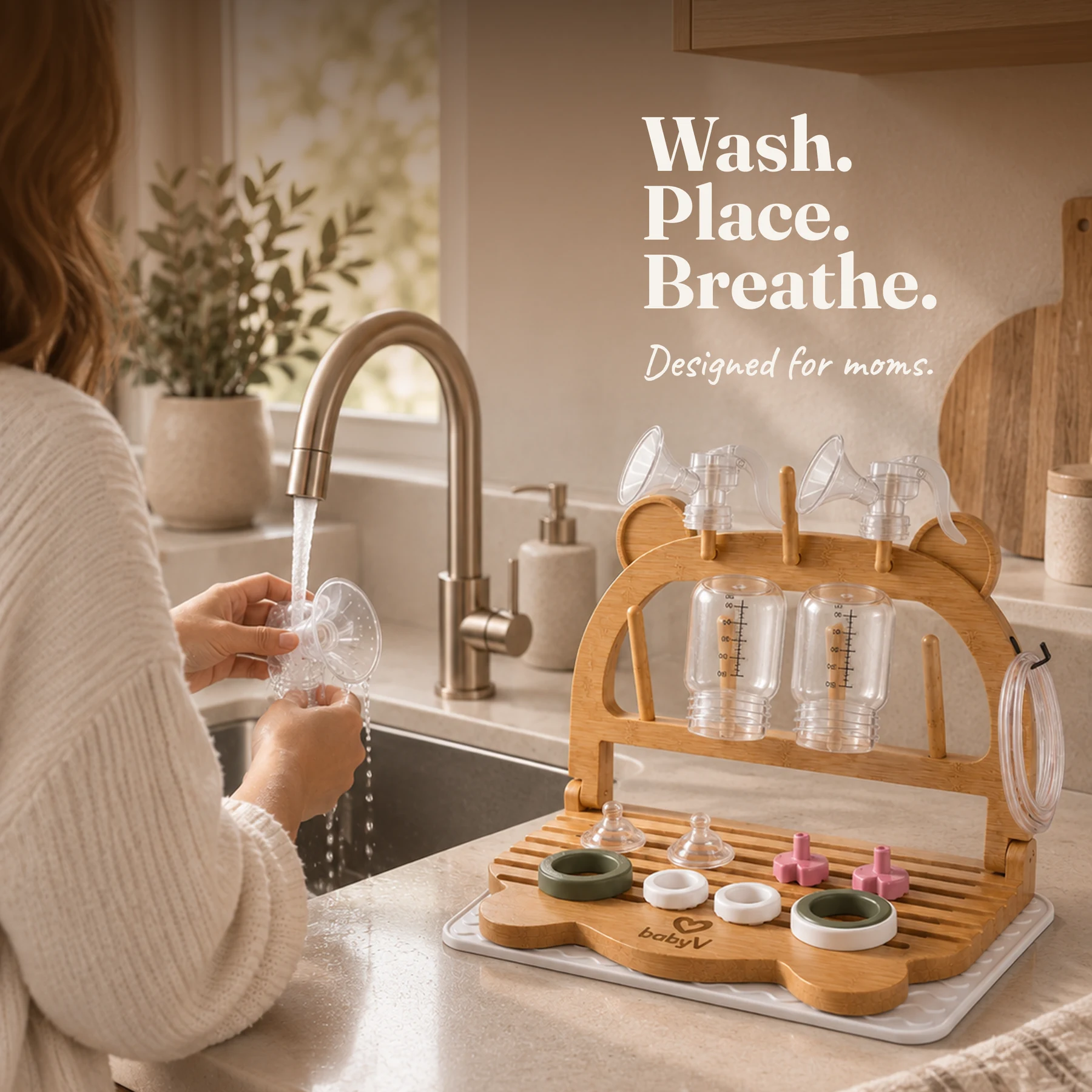 PumpDry bamboo rack beside a sink holding pump bottles, flanges, and small parts for drying after cleaning
